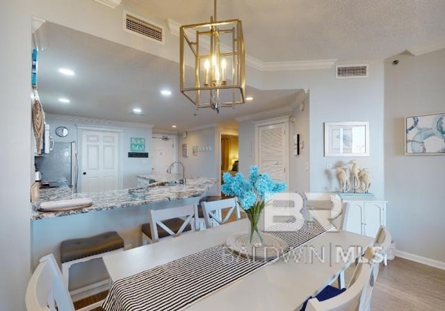 527C Beach Club Trl Unit C-0104, Gulf Shores, AL 36542 - dining space featuring crown molding, light wood-style flooring, recessed lighting, and a chandelier
