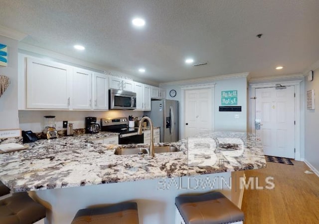 527C Beach Club Trl Unit C-0104, Gulf Shores, AL 36542 - kitchen featuring stainless steel appliances, a peninsula, light stone counters, ornamental molding, and recessed lighting