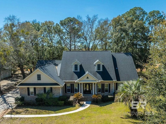 cape cod home with a front lawn