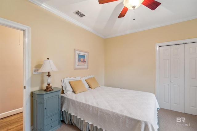 bedroom featuring ceiling fan, visible vents, a closet, and ornamental molding