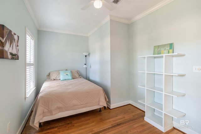 bedroom featuring baseboards, a ceiling fan, wood finished floors, and crown molding