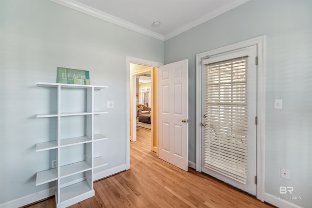 interior space with baseboards, wood finished floors, and ornamental molding