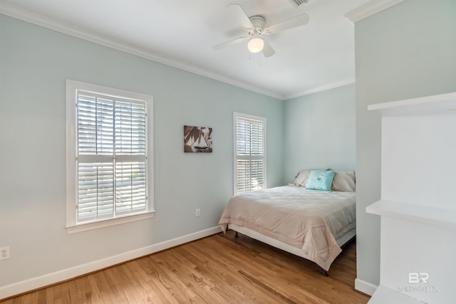 bedroom featuring ceiling fan, wood finished floors, baseboards, and ornamental molding