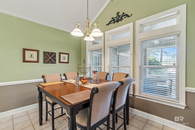 dining room with lofted ceiling, a healthy amount of sunlight, crown molding, and an inviting chandelier