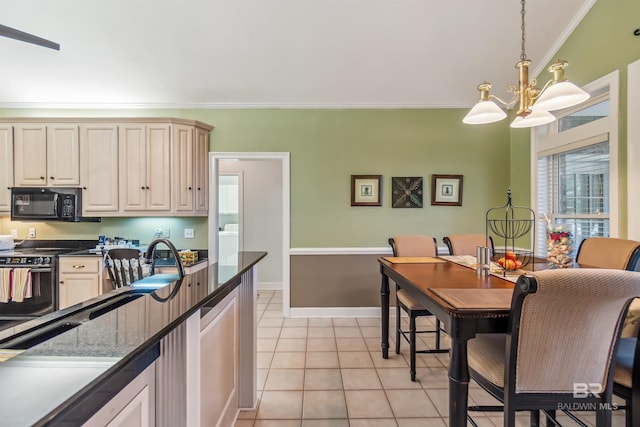 kitchen with crown molding, black microwave, a chandelier, electric range, and washer / clothes dryer