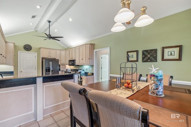 kitchen with vaulted ceiling with beams, cream cabinetry, black microwave, dark countertops, and stainless steel fridge