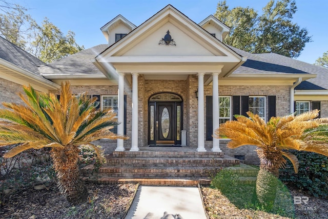 property entrance with brick siding and roof with shingles