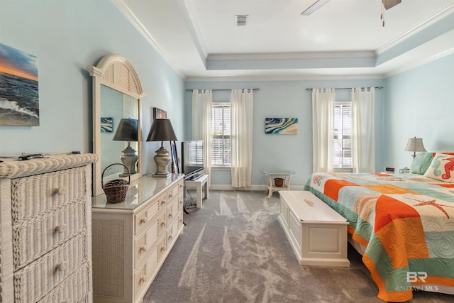 carpeted bedroom with multiple windows, a raised ceiling, and visible vents