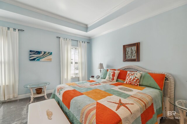 carpeted bedroom with a tray ceiling, baseboards, and ornamental molding