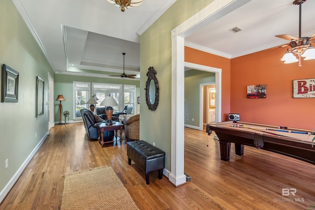 playroom with visible vents, ornamental molding, a ceiling fan, and wood finished floors