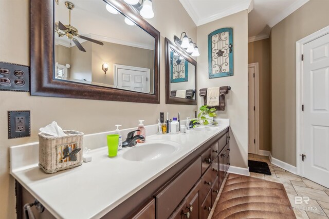 bathroom with crown molding, ceiling fan, baseboards, stone tile floors, and vanity