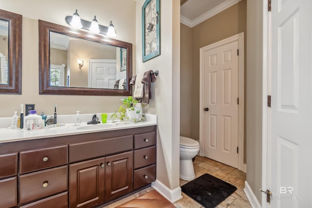 bathroom with baseboards, vanity, toilet, and crown molding