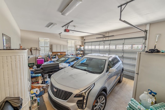 garage featuring a garage door opener and freestanding refrigerator