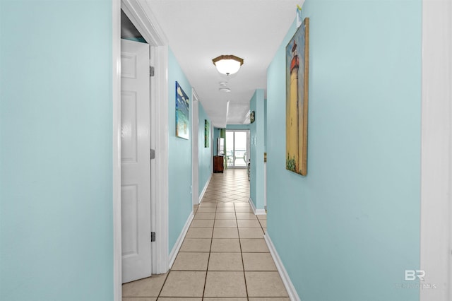 hallway featuring baseboards and light tile patterned floors