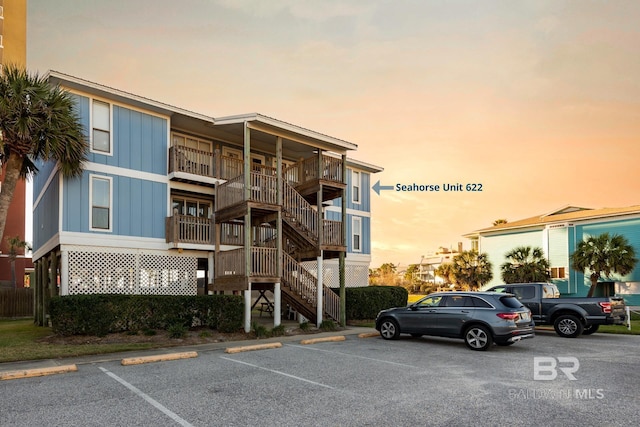 view of building exterior with uncovered parking and stairs