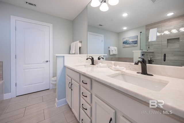 bathroom with vanity, an enclosed shower, and toilet