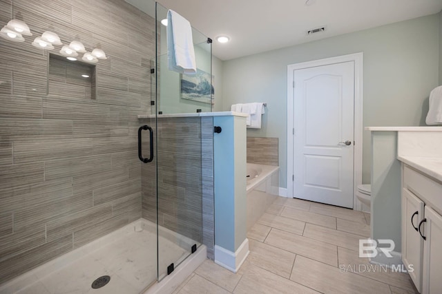 full bathroom featuring vanity, toilet, independent shower and bath, and tile patterned flooring