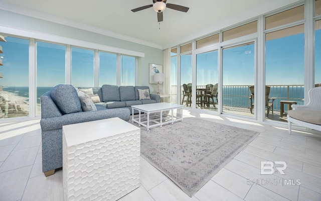 living room with a water view, ceiling fan, ornamental molding, and a wall of windows