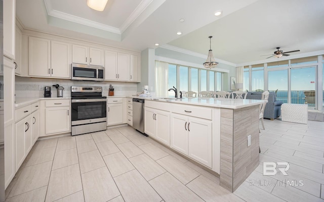 kitchen with stainless steel appliances, kitchen peninsula, sink, and hanging light fixtures