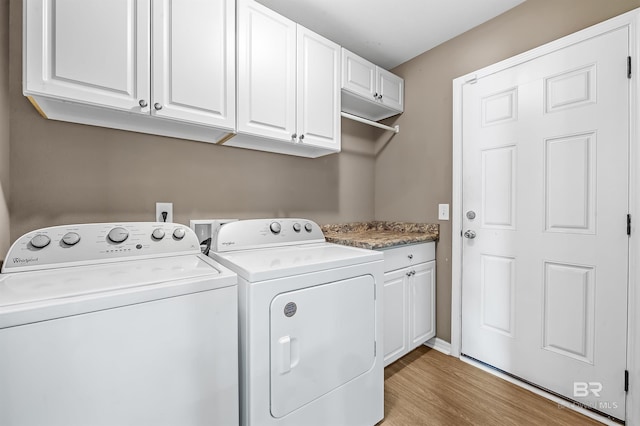 washroom with cabinets, light hardwood / wood-style floors, and washing machine and dryer