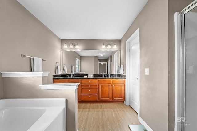 bathroom featuring hardwood / wood-style floors, vanity, and a tub to relax in