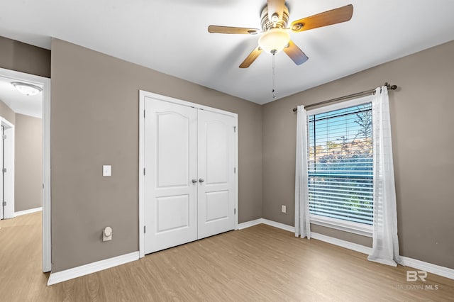 unfurnished bedroom with ceiling fan, light hardwood / wood-style floors, and a closet