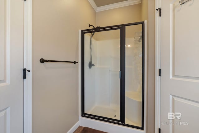 bathroom with baseboards, ornamental molding, and a stall shower