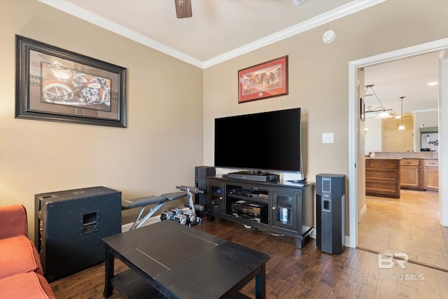 living room with crown molding, baseboards, ceiling fan, and wood finished floors