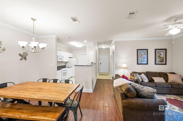 dining area with ceiling fan with notable chandelier, crown molding, and dark hardwood / wood-style floors