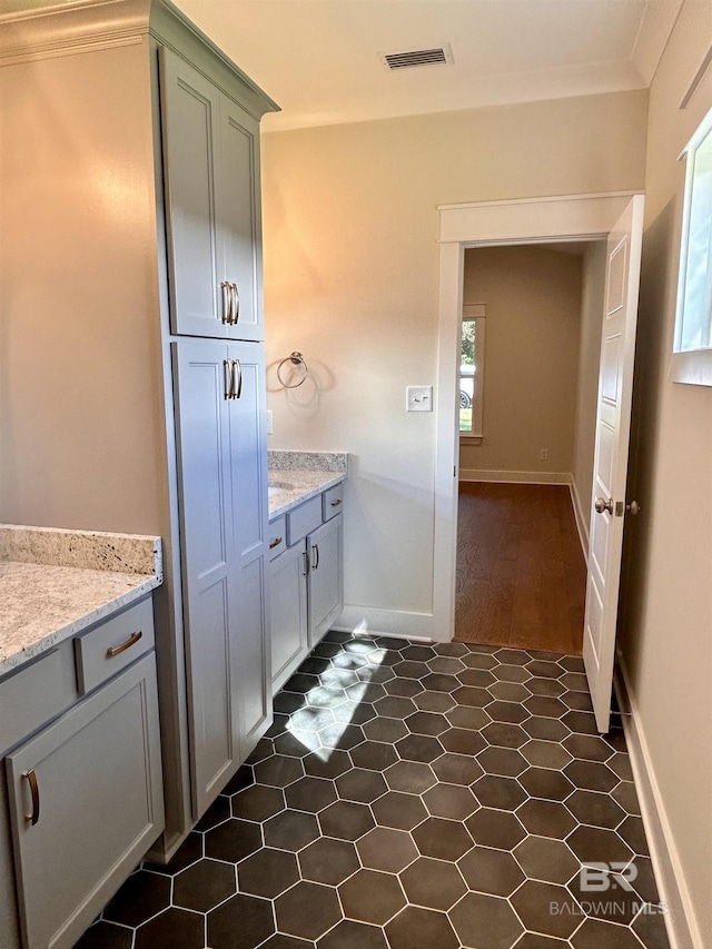 bathroom with vanity, visible vents, and baseboards