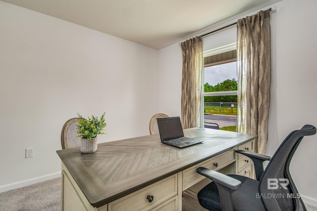 office featuring baseboards and light carpet