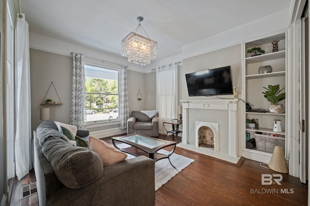 living room featuring built in features, a chandelier, and dark hardwood / wood-style flooring