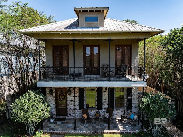 rear view of house featuring a balcony, ceiling fan, and a patio area