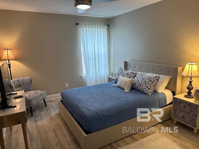 bedroom with wood-type flooring and a textured ceiling