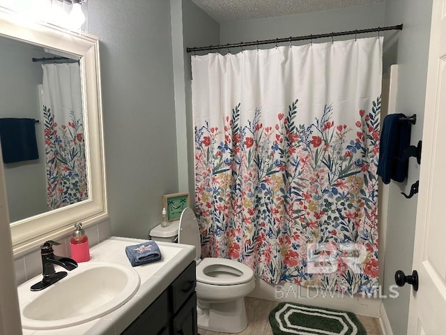 bathroom featuring vanity, a shower with shower curtain, a textured ceiling, and toilet