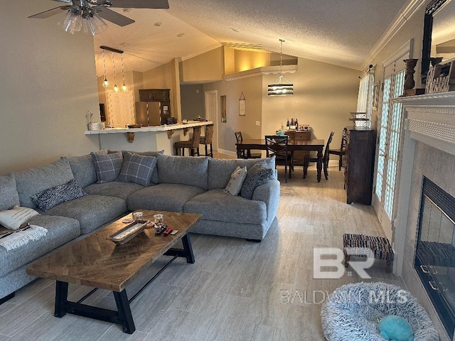 living room featuring a tile fireplace, plenty of natural light, lofted ceiling, and hardwood / wood-style flooring