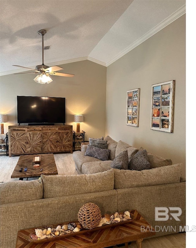 living room featuring hardwood / wood-style floors, vaulted ceiling, ceiling fan, and ornamental molding