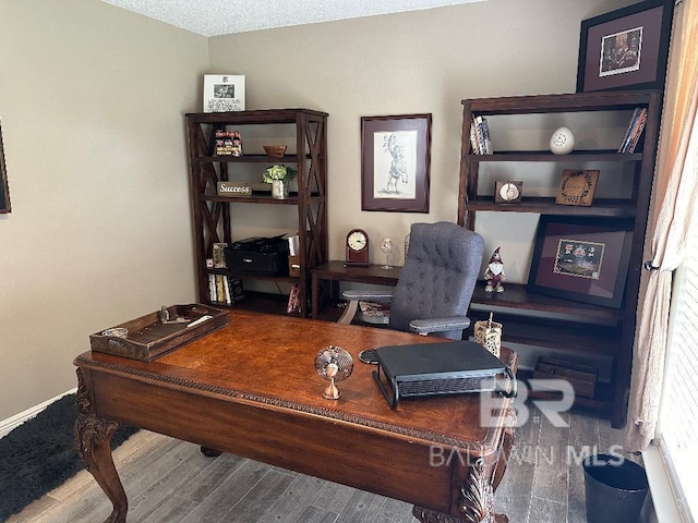 home office with hardwood / wood-style floors and a textured ceiling