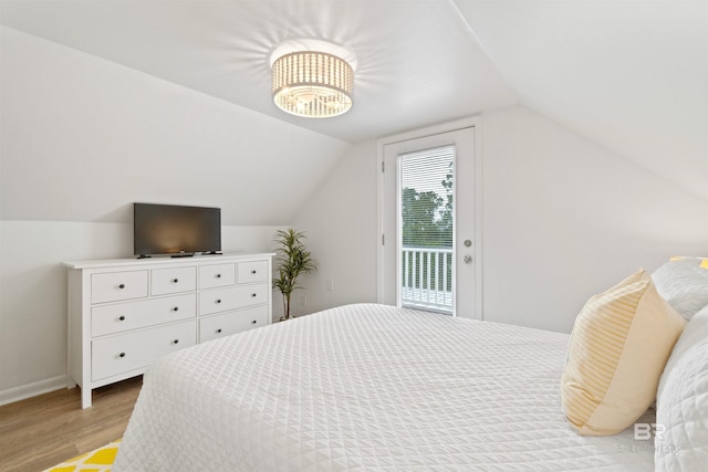 bedroom featuring access to exterior, light wood-type flooring, lofted ceiling, and baseboards