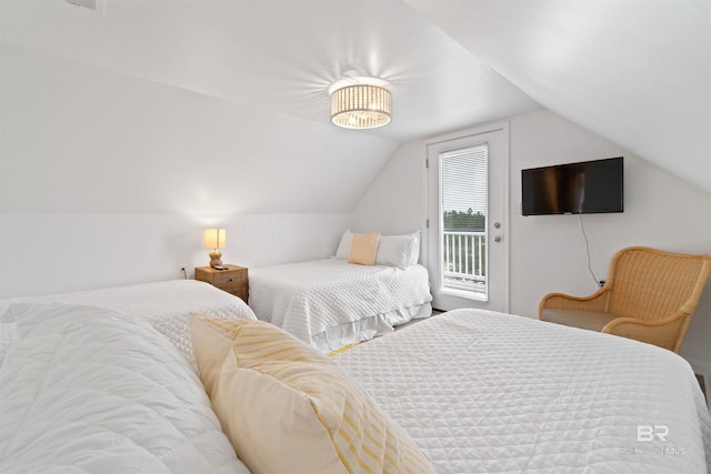 bedroom featuring lofted ceiling and access to exterior