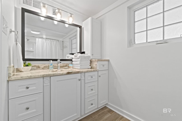 full bath with baseboards, curtained shower, vanity, and wood tiled floor