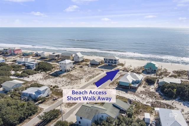 aerial view with a view of the beach, a water view, and a residential view