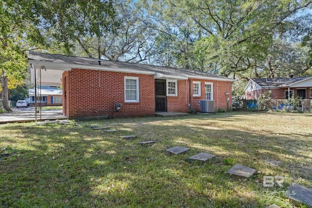 rear view of property with cooling unit, a lawn, and a carport