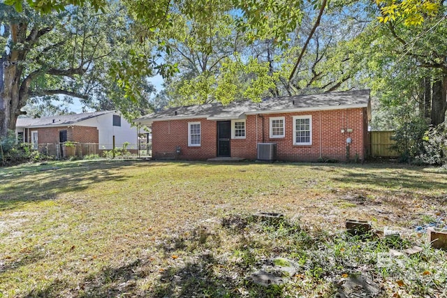 rear view of property with a lawn and cooling unit