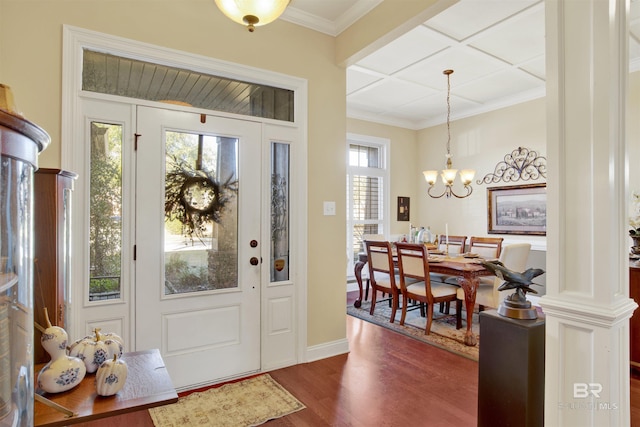 entryway featuring ornate columns, dark hardwood / wood-style flooring, a chandelier, and ornamental molding