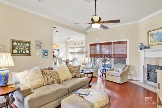 living room with a fireplace, dark hardwood / wood-style flooring, ceiling fan, and crown molding