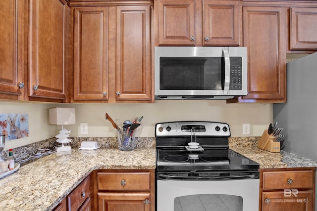 kitchen with light stone countertops and stainless steel appliances