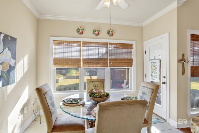 tiled dining space featuring ceiling fan, a healthy amount of sunlight, and crown molding