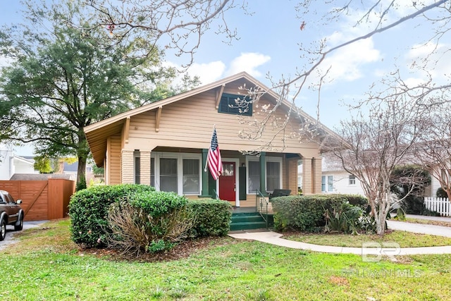 bungalow featuring a porch and a front lawn