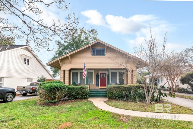 bungalow-style house with covered porch and a front yard